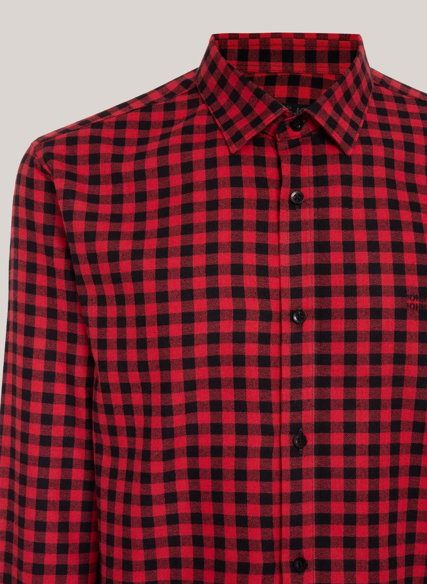 Detalhe da gola e dos botões de uma camisa xadrez vermelha e preta